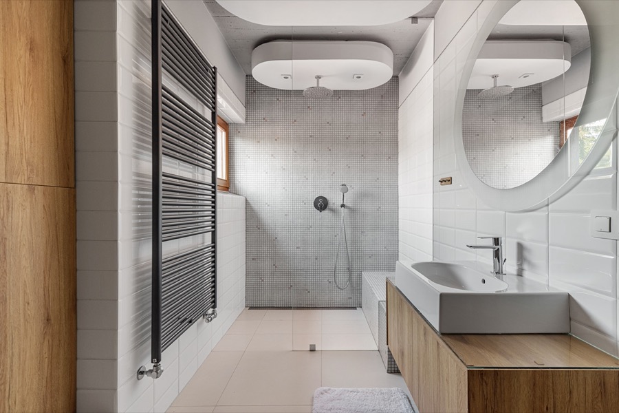 Łazienka w stylu spa z okrągłym lustrem i prysznicem walk-in